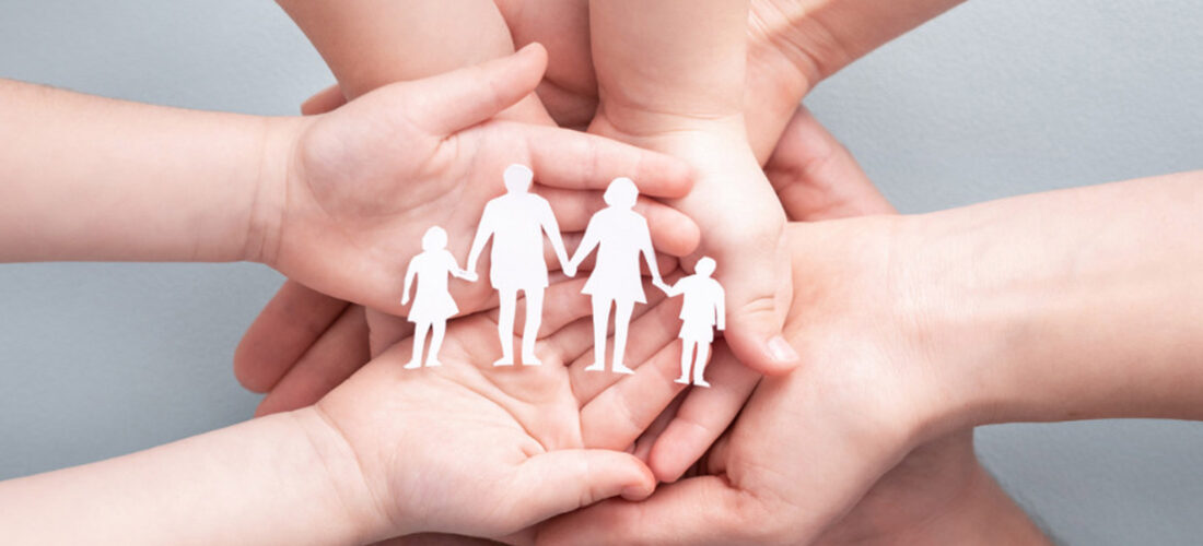 Hands Of A Family Holding A Paper Cut Out Of A Four Person Family. Atkinson Crehan Law Family Wills.