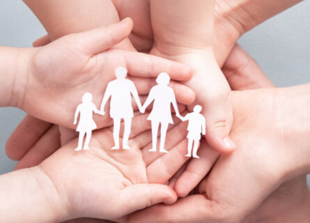 Hands Of A Family Holding A Paper Cut Out Of A Four Person Family. Atkinson Crehan Law Family Wills.